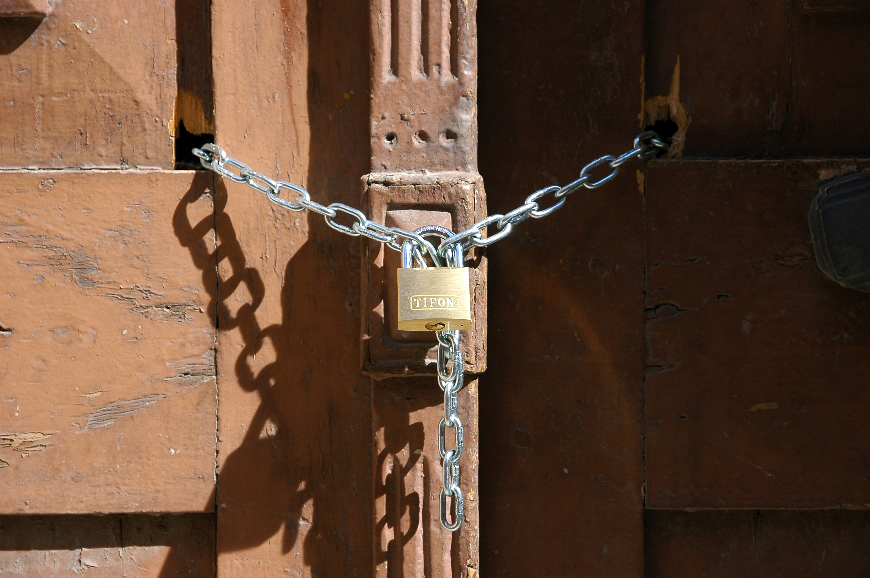 Puerta cerrada con candado y cadena