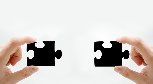 Trabajando en cooperativo Dos manos sosteniendo piezas de puzzle aludiendo a un trabajo en común.