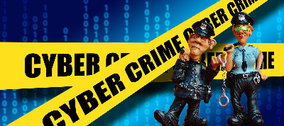dos policías delante de una cinta amarilla con letras negras que rezan cyber crime